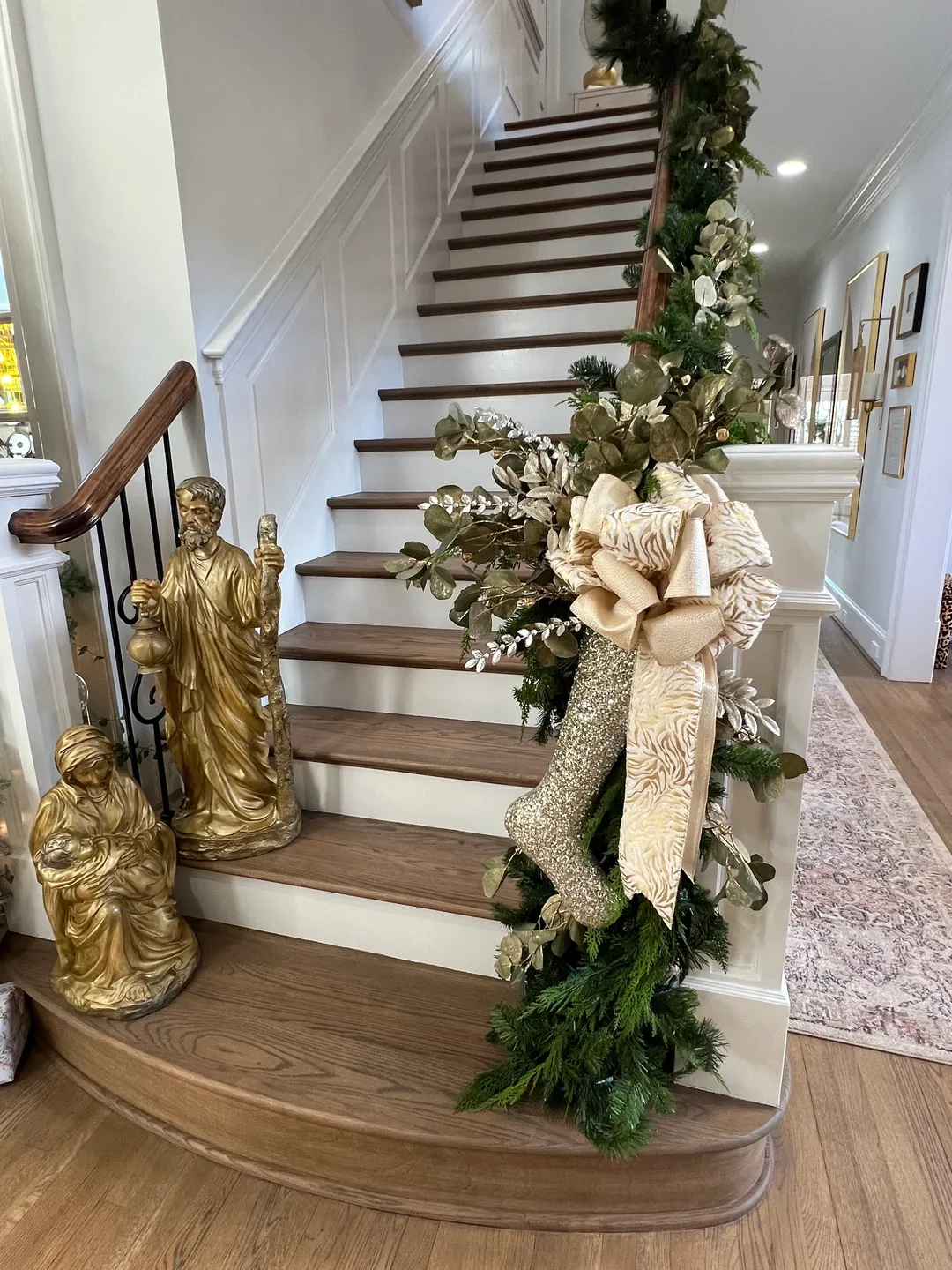 A staircase decorated with christmas decorations and gold statues.